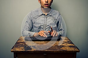 Man typing on keyboard at old desk