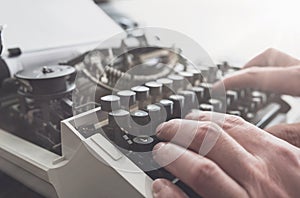 Man typing on keyboard of old manual typewriter