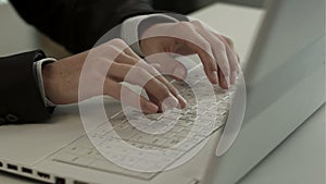 Man typing on laptop computer keyboard