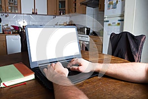 Man typing on a laptop computer in vintage kitchen