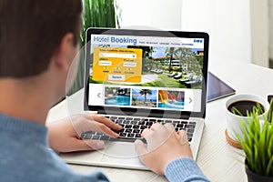 man typing laptop keyboard with online search booking hotel screen