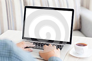 Man typing on a laptop keyboard in the room