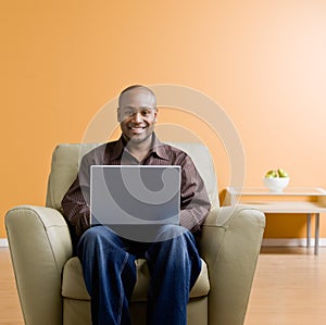 Man typing on laptop in livingroom