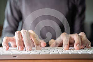 A man typing on a low profile computer keyboard