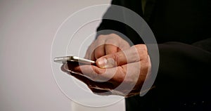 Man is typing message on smartphone sensor display, closeup of hands indoors