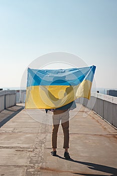 Man with a Ukrainian flag goes to join a demonstration in support of Ukraine. A demonstration against war and atrocities in the