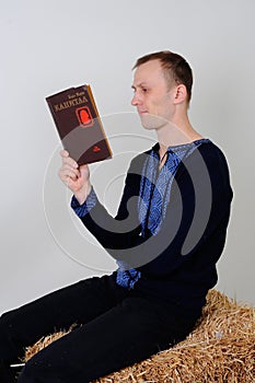 Man in the Ukrainian national costume with a book Capital in R