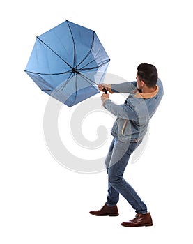Man with umbrella caught in gust of wind on white background