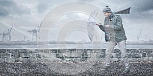 Man with an umbrella is facing a strong wind and rain