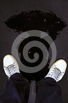 A man with an umbrella. Reflection in a puddle.