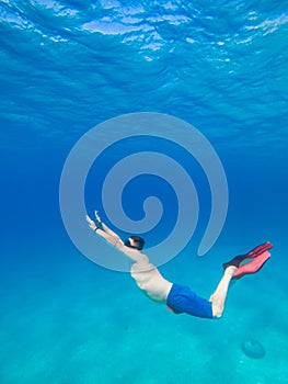 man underwater in scuba mask diving under water