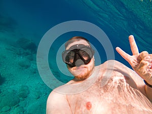 man underwater in scuba mask diving under water