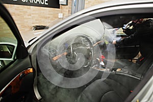 Man in uniform and respirator, worker of car wash center.