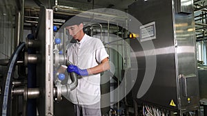 A man in uniform works on a modern dairy farm. Modern cheese factory.