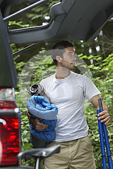 Man Unloading Car In Forest