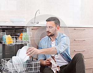 Man unloading dishwasher