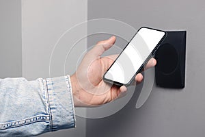 Man unlocking door using smartphone, closeup view