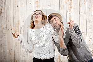 Man unnerve his girlfriend holding phone over wooden background.