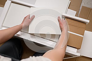 Man unpacking boxes with furniture boards for furniture assembly. Unpacking cardboard boxes after moving house.