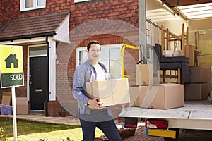 Man Unpacking Moving In Boxes From Removal Truck