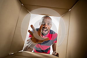 Man unpacking and opening carton box and looking inside
