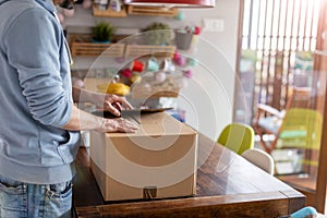 Man unpacking parcel ordered online at home