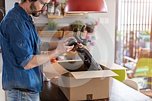 Man unpacking parcel with tools ordered online