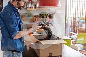 Man unpacking parcel with tools ordered online photo