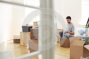 Man unpacking stuff from boxes while furnishing new flat after r photo