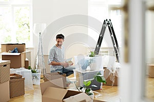 Man unpacking stuff from carton boxes after relocation to new home