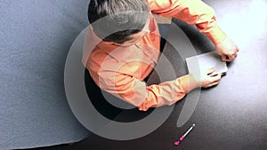 A man unpacks the Bible. He cuts a cellophane film with a knife and removes the packaging from the book