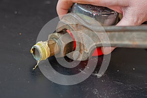 A man unscrews the brass washer on the spigot of the water meter