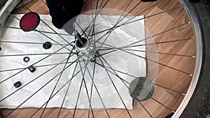 A man unscrews the cone of a ball bearing. Disassembles the rear wheel hub of a mountain bike. The bushing bearing balls are