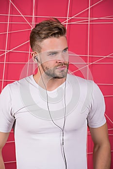 Man unshaven bearded stylish hairstyle listen music or motivating speech earphones. Listen music radio with portable