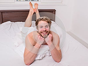 Man unshaven handsome happy smiling torso relaxing bed. Guy macho lay white bedclothes. Man feel full of energy