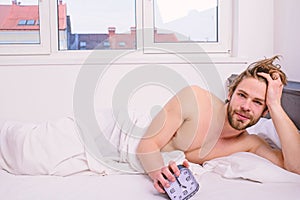 Man unshaven lay bed hold alarm clock. Man unshaven bearded wakeful face having rest. Stick schedule same bedtime wake