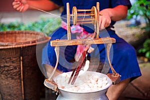 Man Unwinding And Reeling Silk Cocoons In Factory