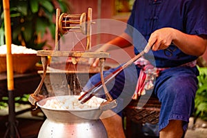 Man Unwinding Silk From Cocoons In Large Hot Pot