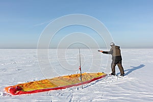 Man unwinding slings at kite on snow, Novosibirsk,Russia