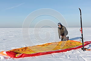 Man unwinding slings at kite on snow, Novosibirsk,Russia