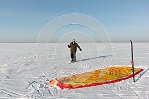 Man unwinding slings at kite on snow, Novosibirsk,Russia