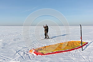 Man unwinding slings at kite on snow, Novosibirsk,Russia