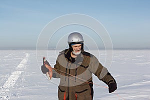 Man unwinding slings at kite on snow, Ob reservoir, Novosibirsk