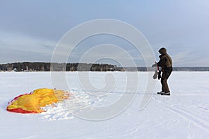 Man unwinding slings near a kite in the snow, Ob reservoir, Novosibirsk, Russia