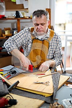 Man upholstering chair in his workshop