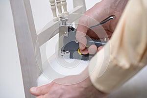 Man upholstering a chair seat