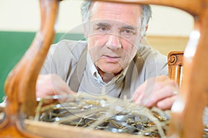 man upholstering chair in workshop