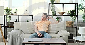 Man Upset from boredom with phone on sofa