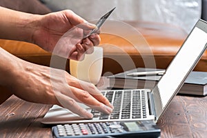 Man use credit card to buy product on laptop