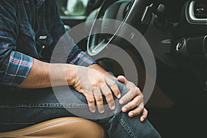 Man use hands hold and massage on his knee in the car while stop. Outdoor shooting for transport and healthcare